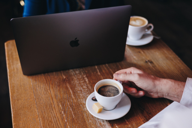 kennismakingsgesprek met webbouwer koffie en laptop in cafe